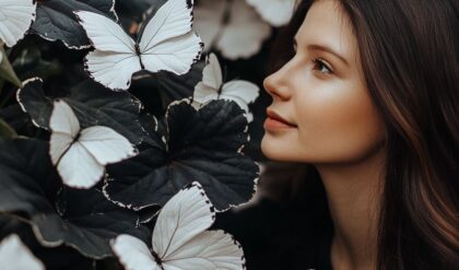 A woman admiring the delicate white Butterfly Begonia flowers with dark foliage